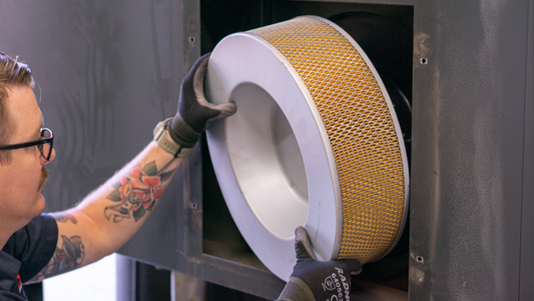 service technician changing an air filter on a kaeser compressor